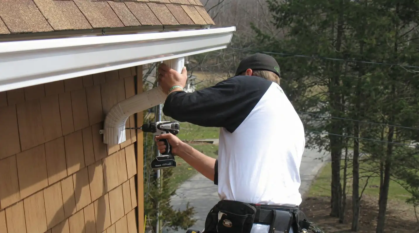 Professional contractor installing tan vinyl siding panels on a residential home exterior in Los Angeles, CA
